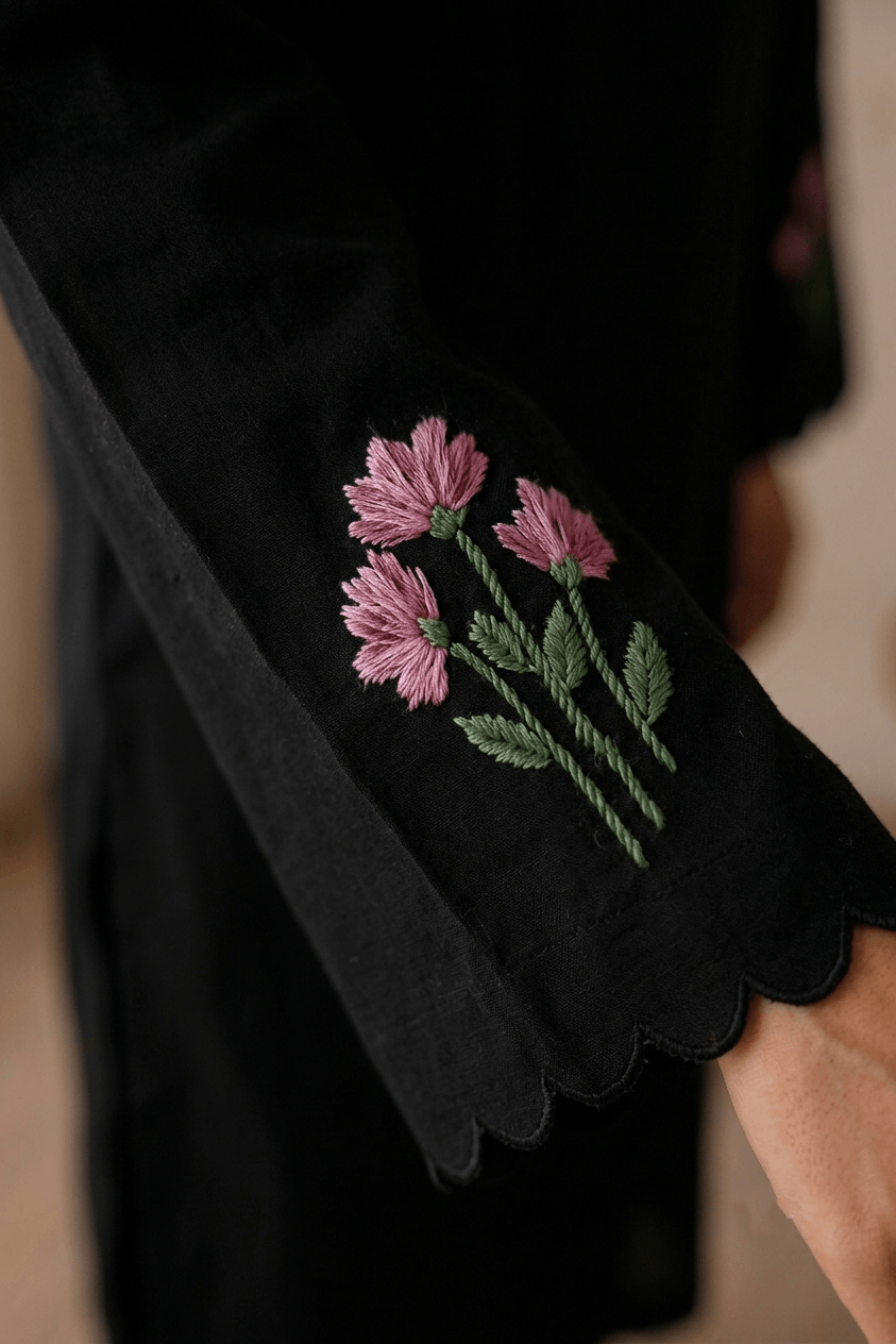 Close-up of hand embroidered floral design on sleeve of black cotton lawn kurta