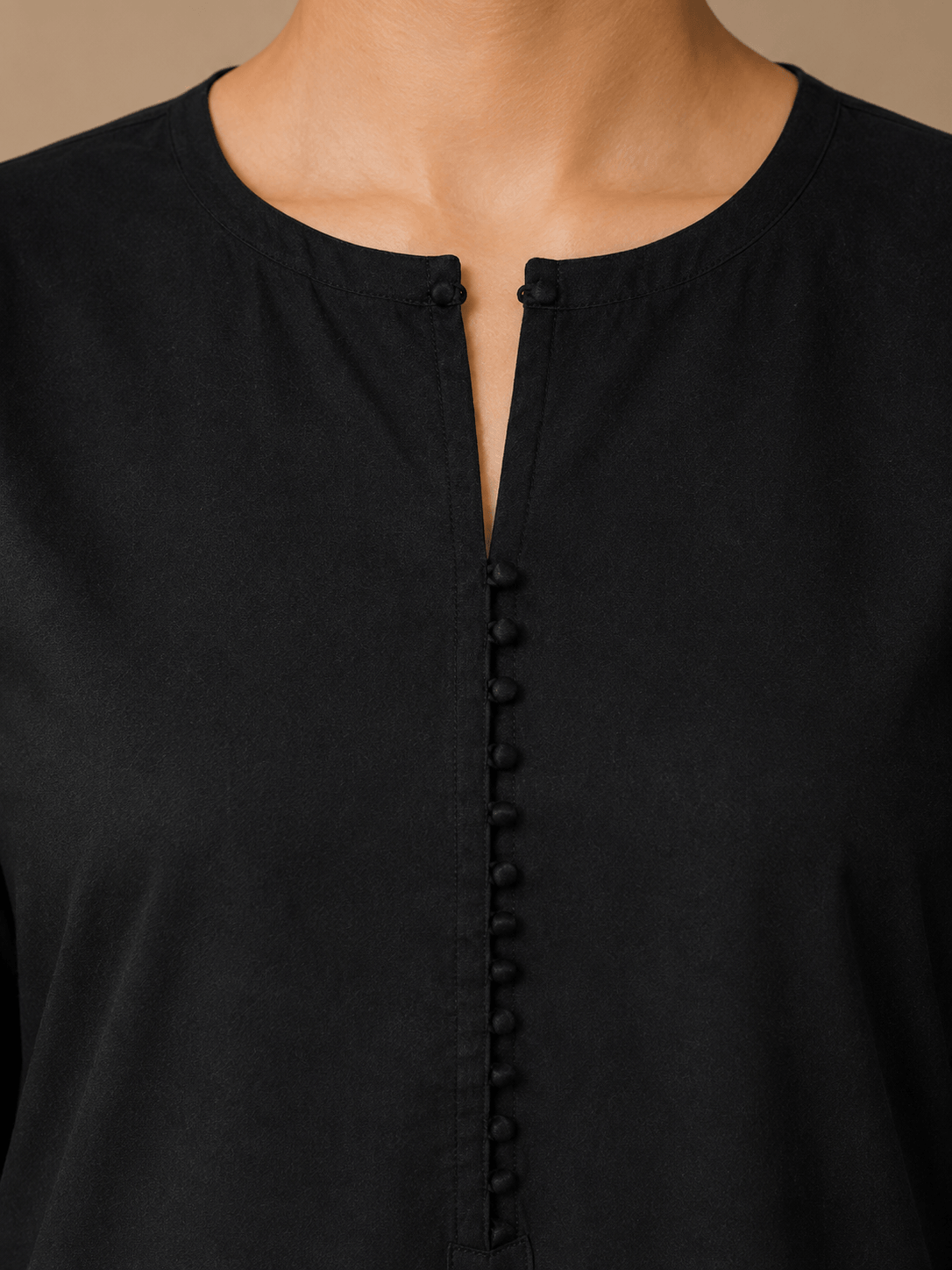 Close-up of round neckline and button-down front on black cotton lawn kurta